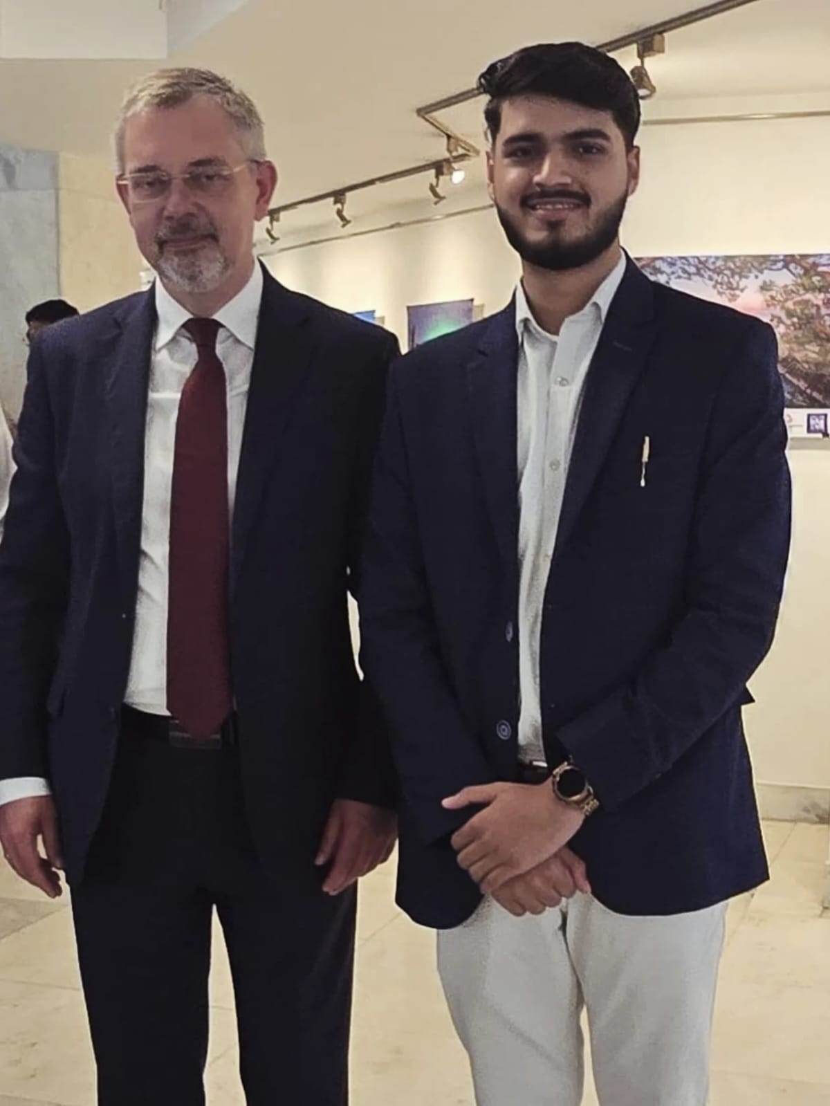Akshat Mehrotra standing next to a male dignitary.